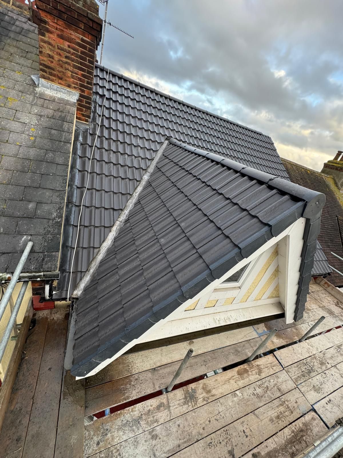 Close-up of a newly tiled roof ridge in grey tiles