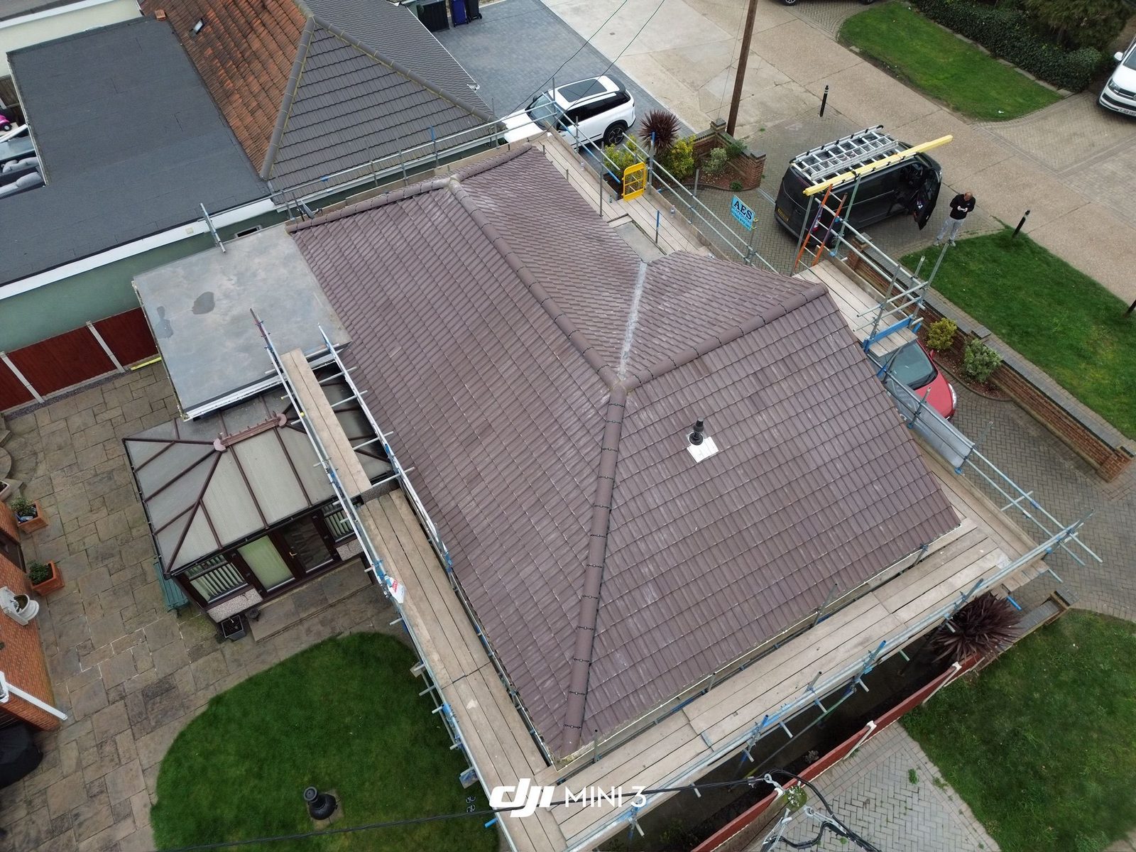 Aerial view of a newly completed grey tiled roof on a detached home