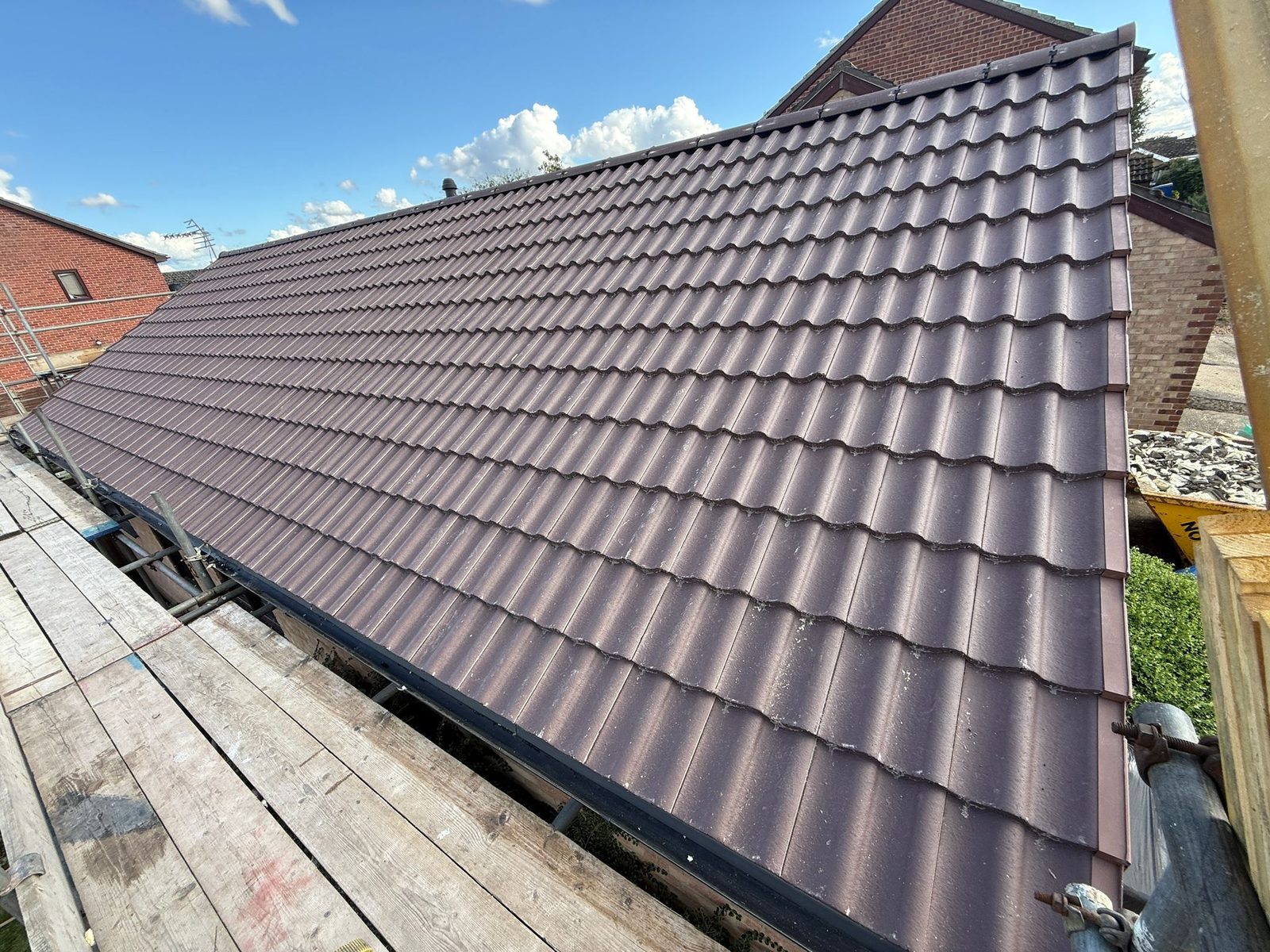 Completed tiled roof with chimney on a detached house