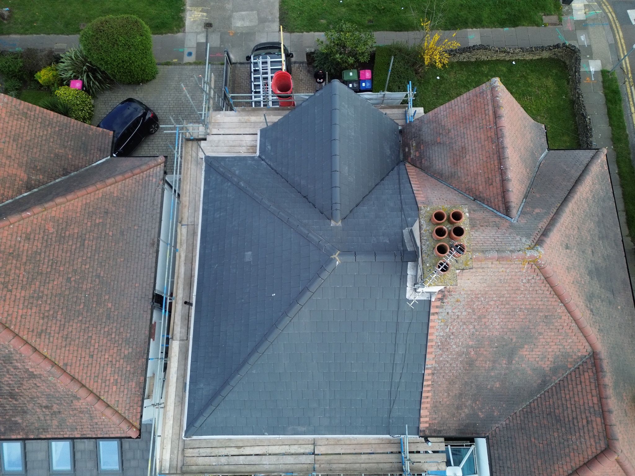 Aerial view of a newly fitted grey slate hipped roof in Essex