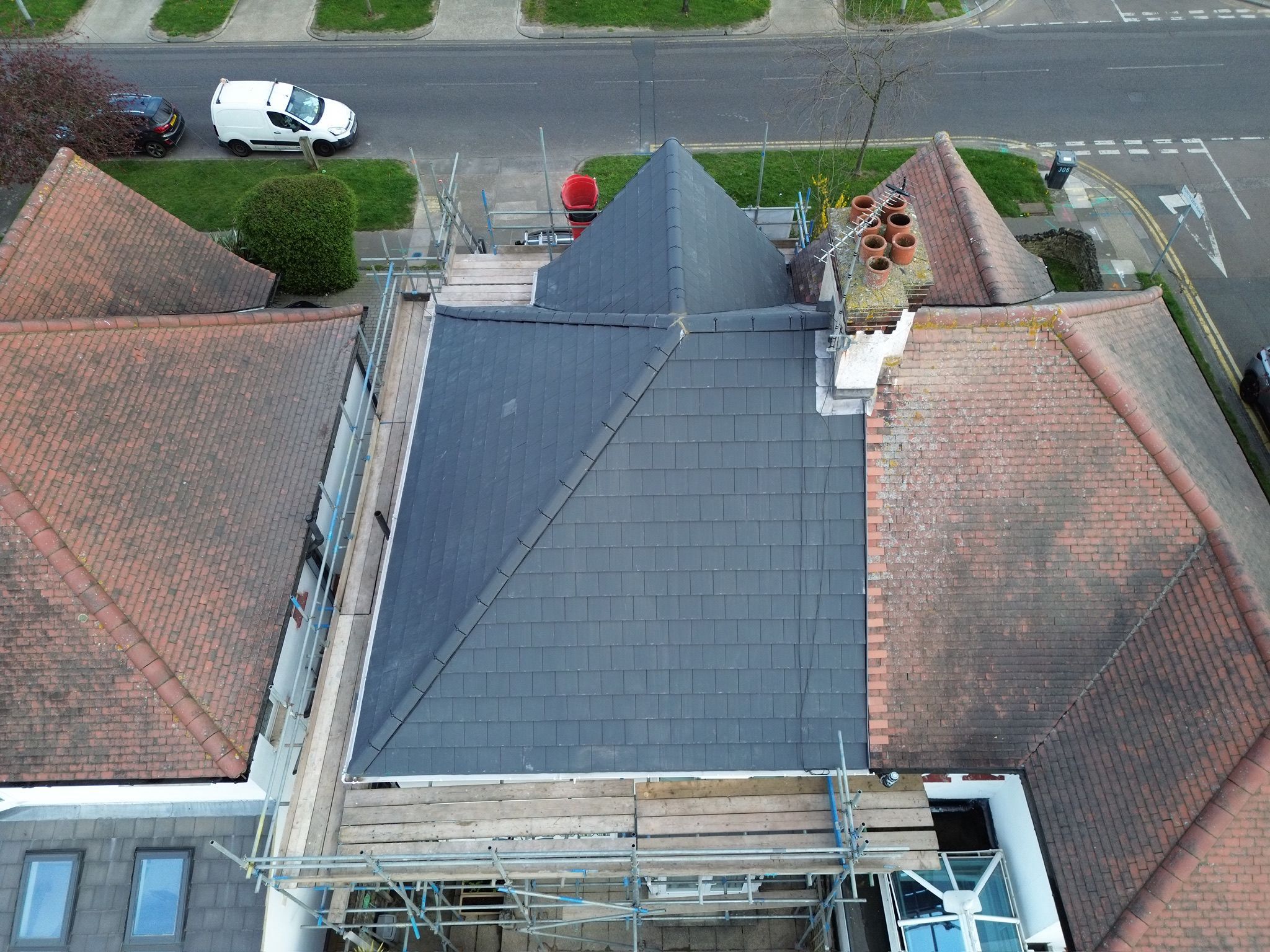 New grey slate roof with red ridge tiles viewed from above
