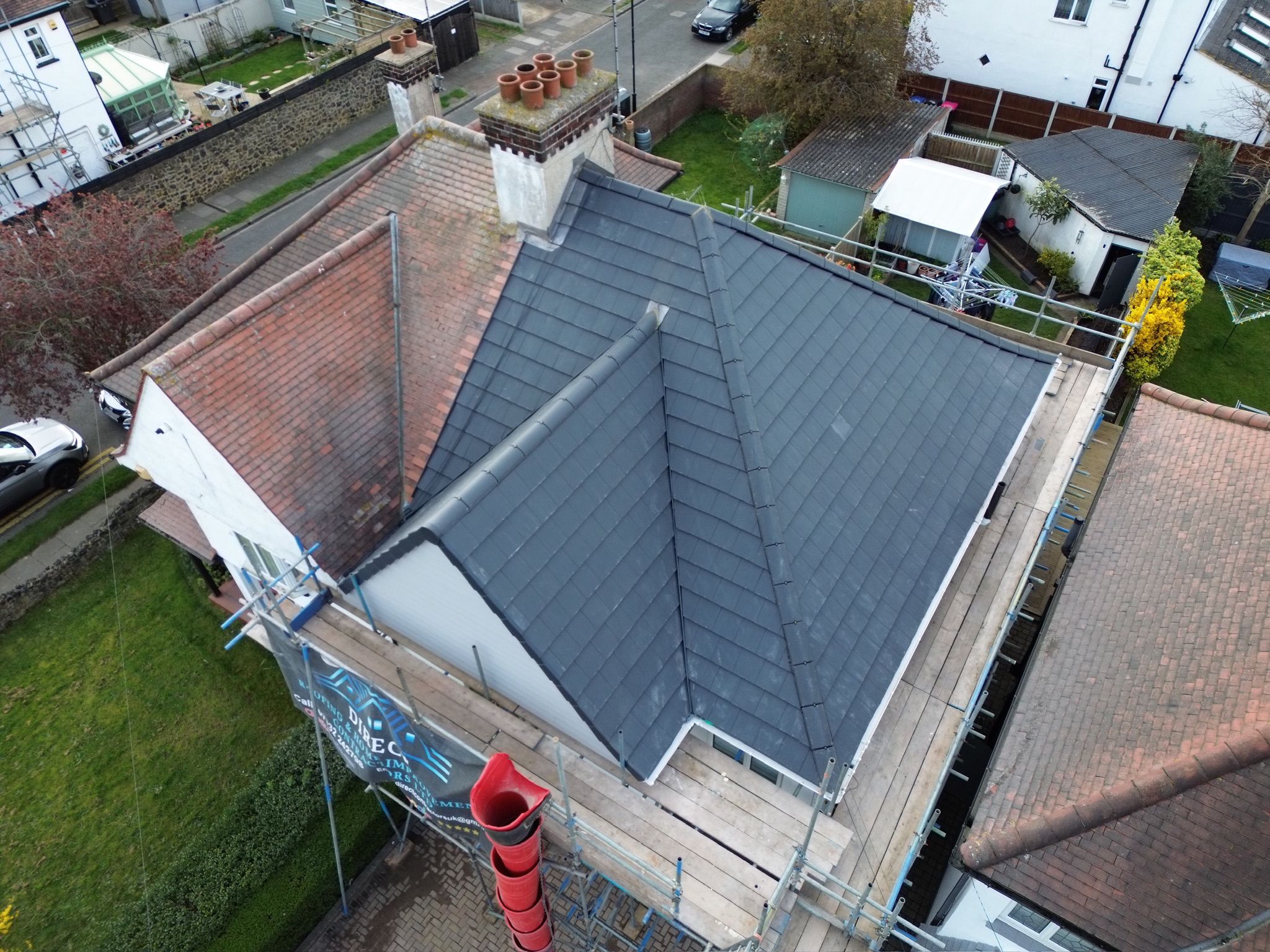 Re-roofed property with new grey slate and scaffolding in place